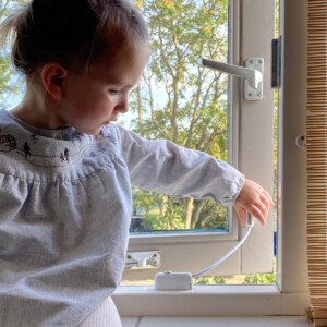 Child interacting with window security device.