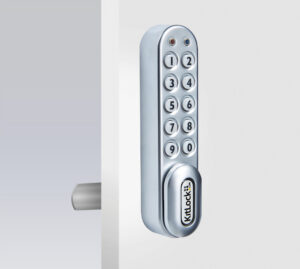 Silver keypad lock on white door, angled view.